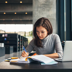A researcher at a desk in a library.