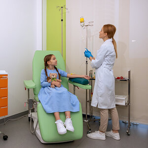 A young girl receiving cancer treatment in a hospital.