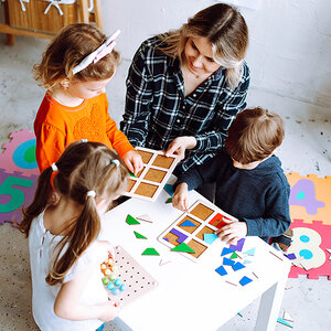An early childhood teacher surrounded by students. An early childhood teacher surrounded by students.