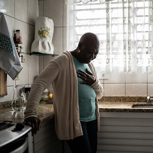 A woman under stress, clutching her chest in pain.