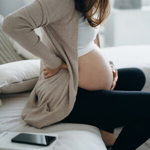 A pregnant woman holding her stomach.