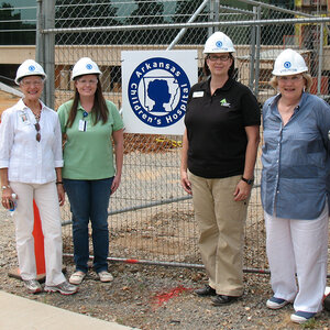 A group of women wearing hard hats at a construction site with a sign reading: Arkansas Children's Hospital. A group of women wearing hard hats at a construction site with a sign reading: Arkansas Children's Hospital.