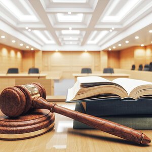 A courtroom with and open law book at the forefront.