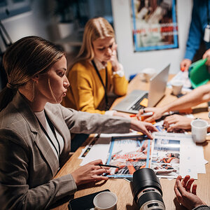 Journalists discussing stories in a newsroom.