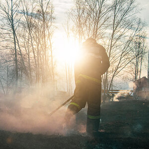A firefighter extinguishing the remains of a wildfire. A firefighter extinguishing the remains of a wildfire.