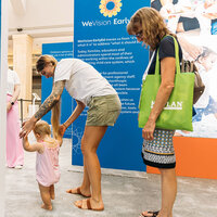 A mother walking her toddler into an education center. A mother walking her toddler into an education center.