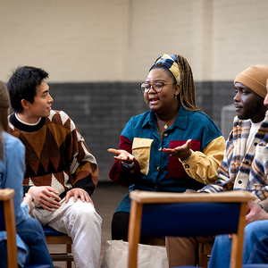 “Three people seated having a conversation.