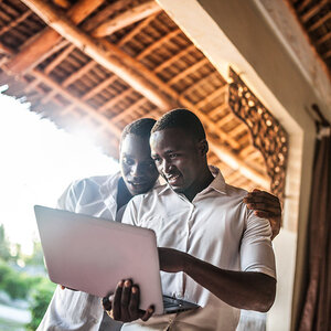 Two young men working together on a computer. Two young men working together on a computer.