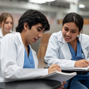 Two health sciences students sitting together during a class. Two health sciences students sitting together during a class.