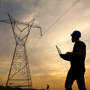 An electrical engineer uses a laptop computer to test a power line. An electrical engineer uses a laptop computer to test a power line.