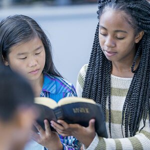 Teens reading bible verses together.