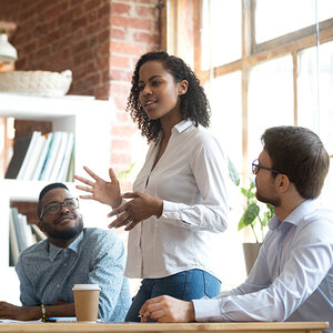 A Black woman leads a discussion during a meeting.