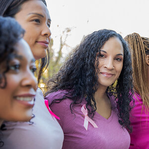 A group of African American women wearing cancer survivor ribbons. A group of African American women wearing cancer survivor ribbons.