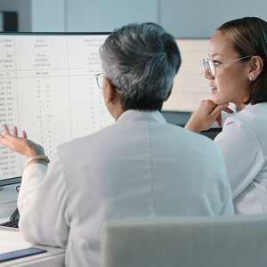 Two doctors reviewing health data. Two doctors reviewing health data.