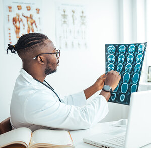 A doctor examining a brain scan. A doctor examining a brain scan.