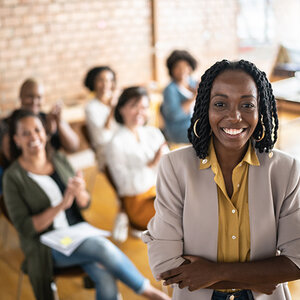 A Black nonprofit leader in front of her team