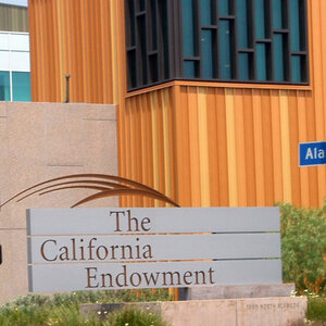 The exterior of a modern wood, glass, and stone building with a sign out front that reads: The California Endowment. The exterior of a modern wood, glass, and stone building with a sign out front that reads: The California Endowment.