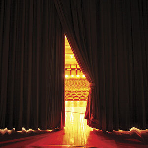 A theater stage with the curtain slightly open to the audience. A theater stage with the curtain slightly open to the audience.