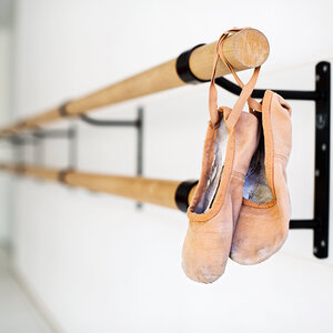 Ballet shoes dangling from a bar. Ballet shoes dangling from a bar.
