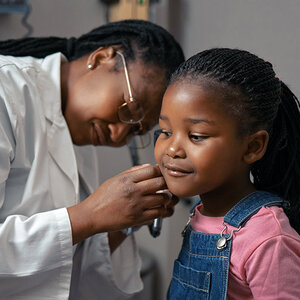 A young girl gets a checkup from her pediatrician. A young girl gets a checkup from her pediatrician.