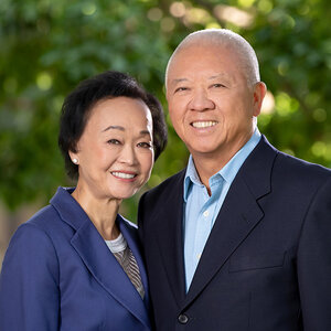 A well-dressed Chinese husband and wife pose for a portrait in garden – a photo of Peggy and Andrew Cherng.