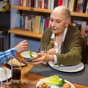 An elderly woman sits at a Passover dinner with her grandson. An elderly woman sits at a Passover dinner with her grandson.
