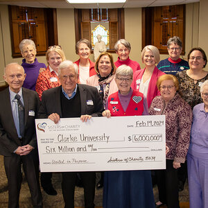 A group of people pose for a photo with an oversized check worth six million dollars. A group of people pose for a photo with an oversized check worth six million dollars.