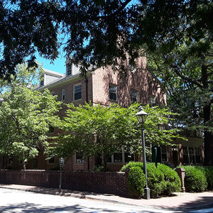 A brick college building shaded by trees - Brown Hall. A brick college building shaded by trees - Brown Hall.