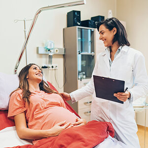 A pregnant woman and her doctor share a joyous moment. A pregnant woman and her doctor share a joyous moment.