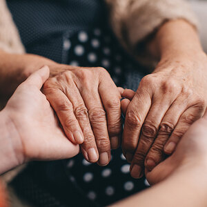 Two people grip each other's hands at the fingers. Two people grip each other's hands at the fingers.