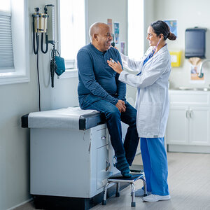 A man having his heart checked by a doctor. A man having his heart checked by a doctor.