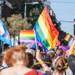 People marching in a gay pride event carrying rainbow flags. People marching in a gay pride event carrying rainbow flags.