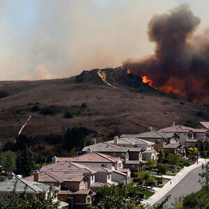 An image of a burning landscape as a wildfire approaches a row of homes