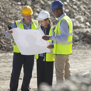 Contractors look at the blueprint of a new building.