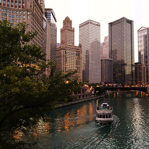 A ferry boat on a river in a city with tall buildings - downtown Chicago. A ferry boat on a river in a city with tall buildings - downtown Chicago.
