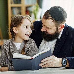 A young girl reading a book with a Jewish teacher. A young girl reading a book with a Jewish teacher.