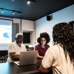 A group of professionals sharing a presentation. A group of professionals sharing a presentation.