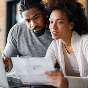 An African American couple review financial records.