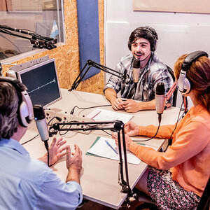 A group of radio journalists recording a show. A group of radio journalists recording a show.