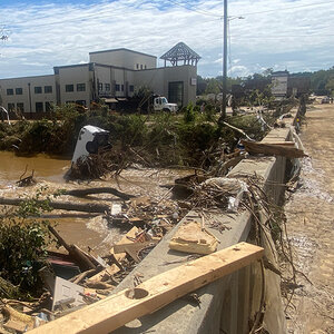 A van is amongst the debris up agains the side oa a bridge after a flood. A van is amongst the debris up agains the side oa a bridge after a flood.