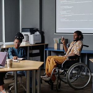 A man in a wheelchair giving a presentation. A man in a wheelchair giving a presentation.