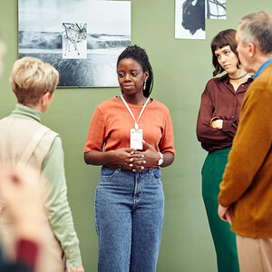 A museum curator speaking with patrons. A museum curator speaking with patrons.