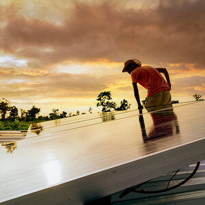 A worker installing solar panels.