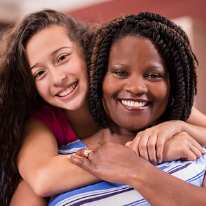 A foster child hugs her foster mother.