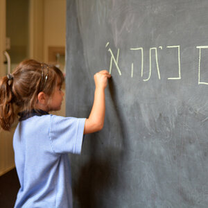 A child writing in Hebrew on a chalboard. A child writing in Hebrew on a chalboard.