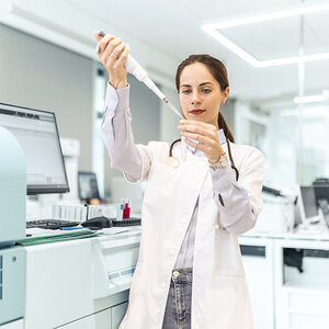 A researcher using a pipette for test analysis. A researcher using a pipette for test analysis.