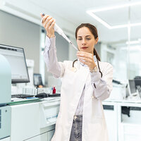 A researcher using a pipette for test analysis.