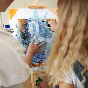 A student and her art therapist working on finger painting. A student and her art therapist working on finger painting.