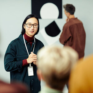 An art curator addressing a crowd. An art curator addressing a crowd.