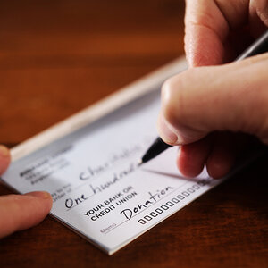 A check being signed to provide a gift to a nonprofit